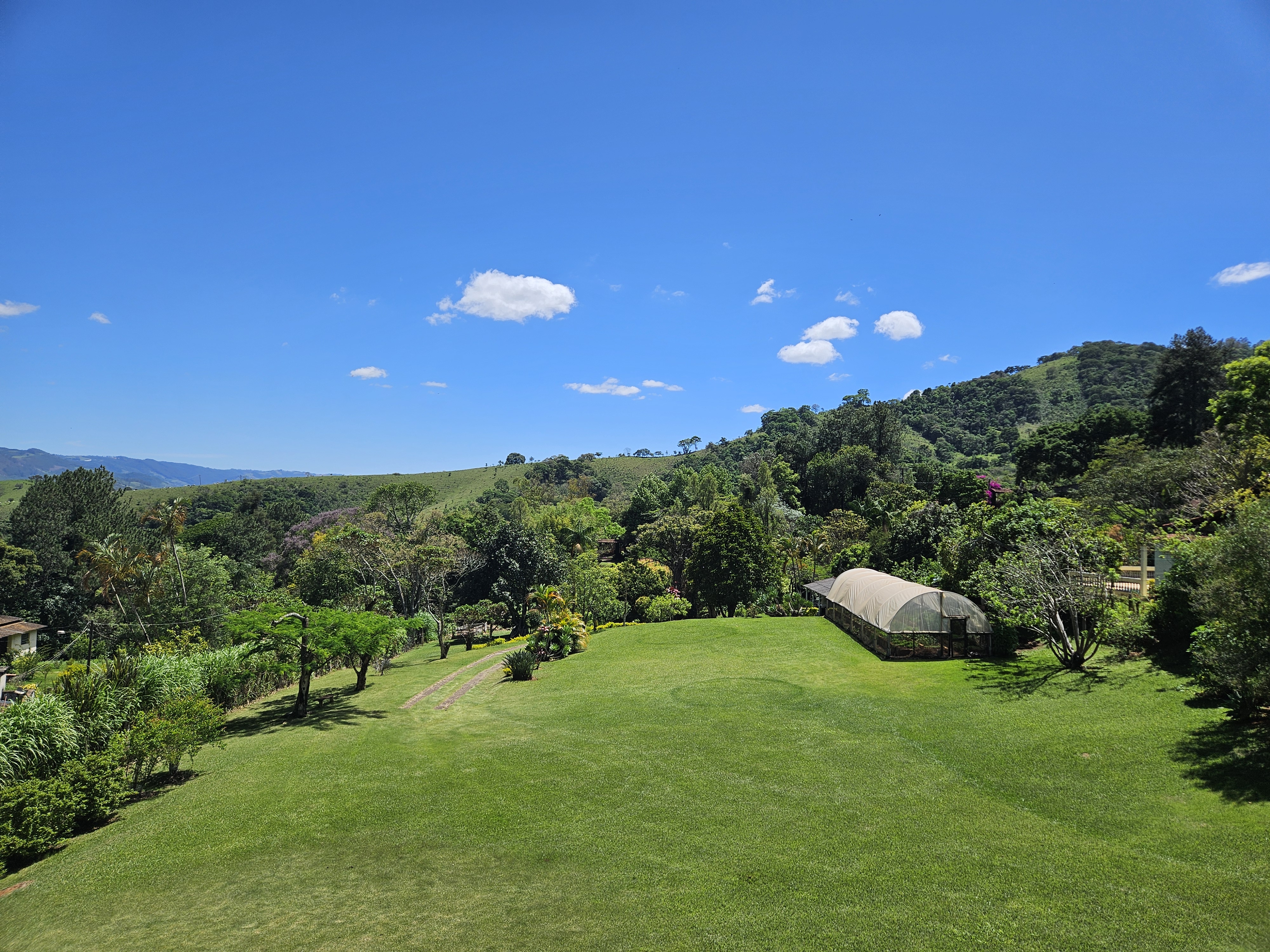 Gramado, jardins, estufa e montanhas no Sítio Pomodoro